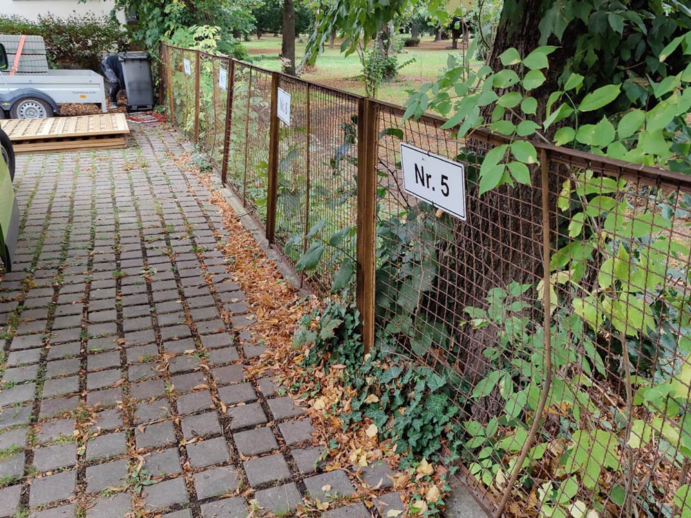 Vorher Bild von einem Parkplatz mit Zaun